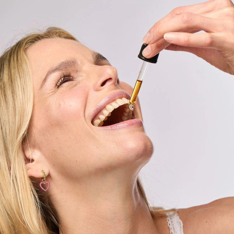 Person using a dropper to take a liquid herbal tincture.